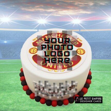 Soccer-themed cake with Manchester United logo and red-black border for sports celebration.