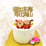 Golden Chinese New Year cake topper with lucky gods and peach figurines, crafted by LE PETIT EMPIRE Designer Cakes.
