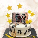 Gold star cake toppers and musical note decorations on a white fondant cake.