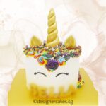 Colorful unicorn-themed cake with rainbow floral decorations, perfect for special celebrations, by LE PETIT EMPIRE Designer Cakes.